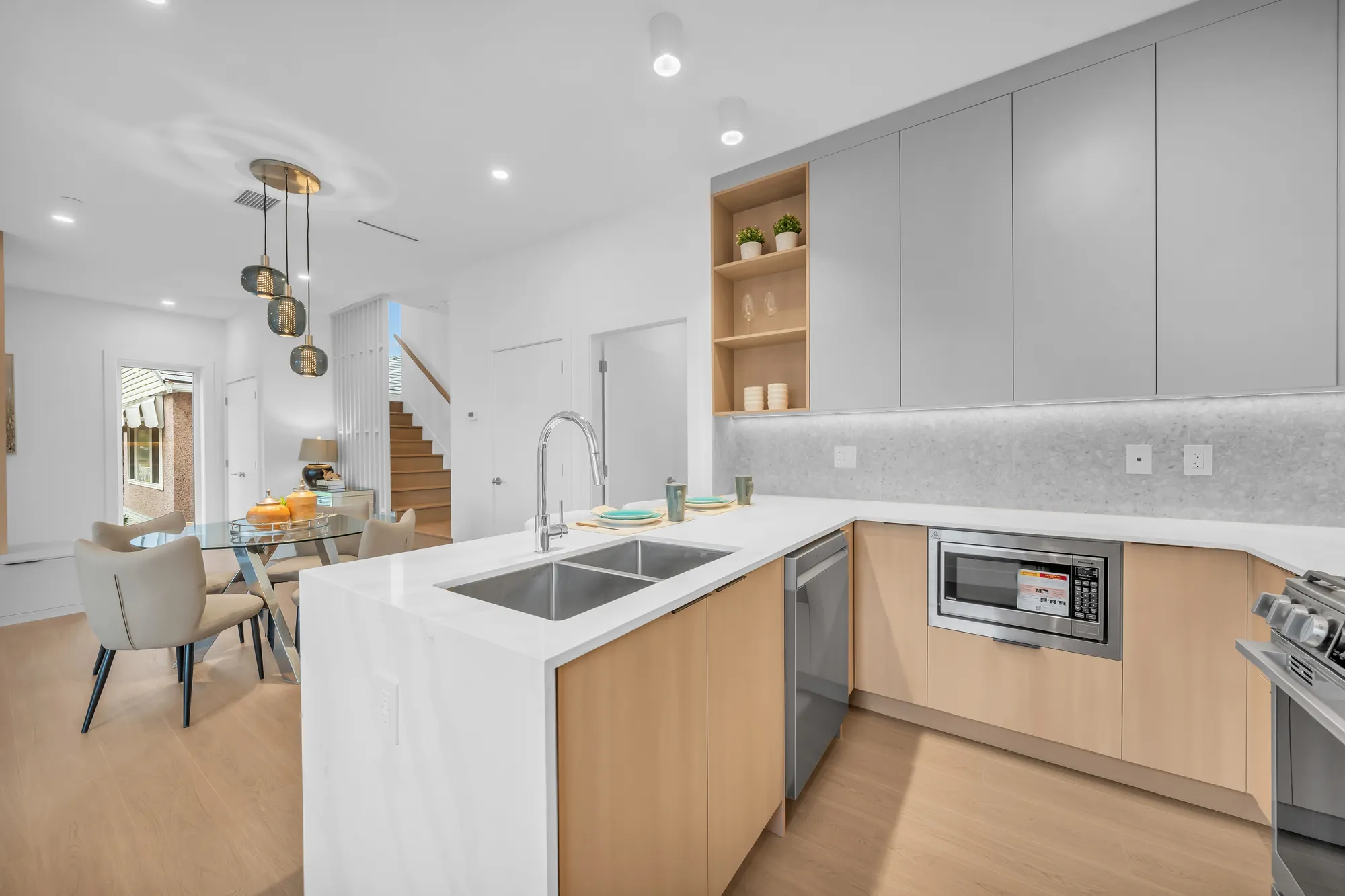 The sink below the window, a built-in microwave, the dining table beyond